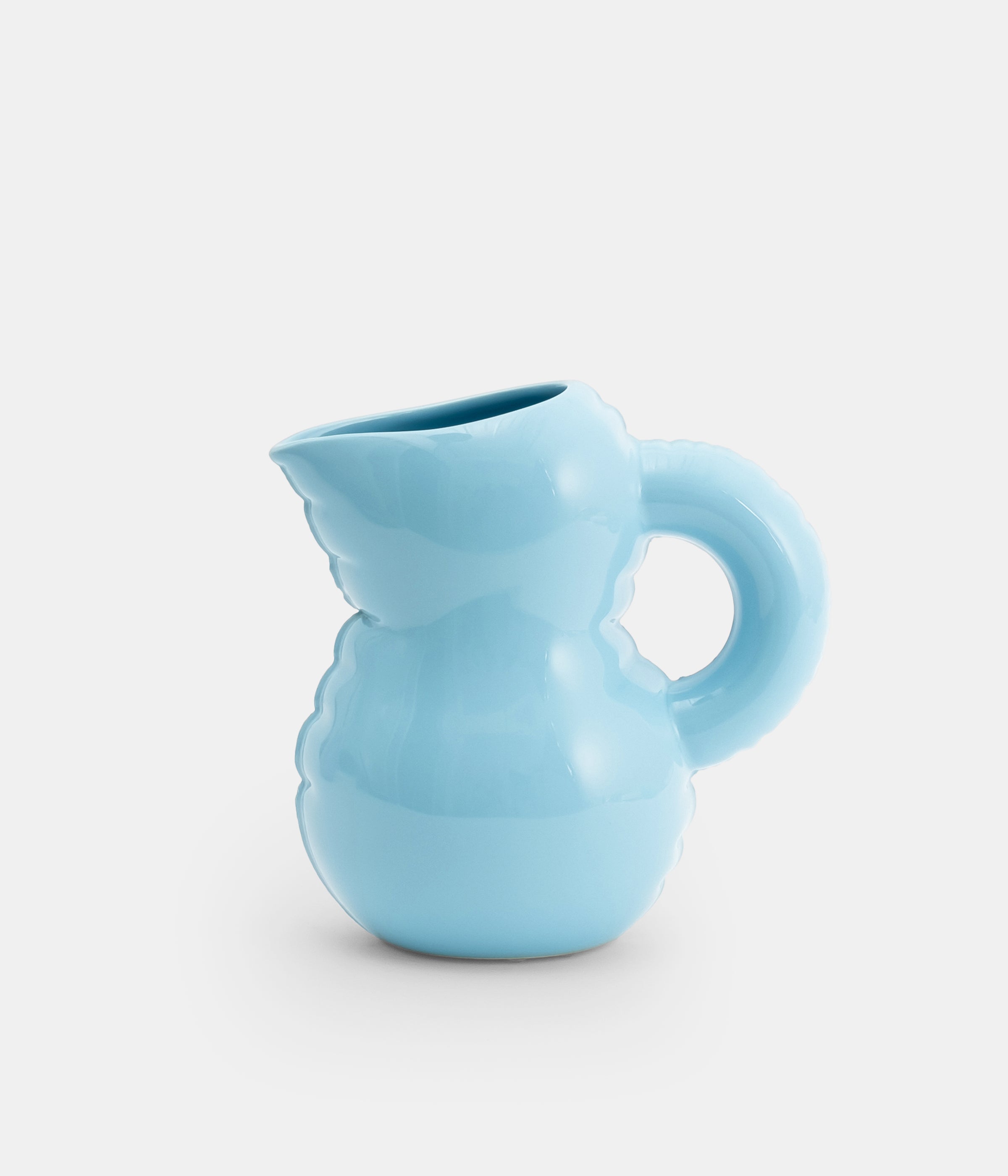 A ceramic jug with a sky blue glossy finish, featuring a handle and a spout, isolated on a white background.